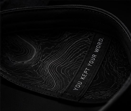 Artwork topográfico y mensaje oculto bajo la visera de la PACE Running Cap.