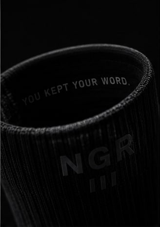 Puño de la PACE Performance Sock con el mensaje “YOU KEPT YOUR WORD.” y el logo NGR.